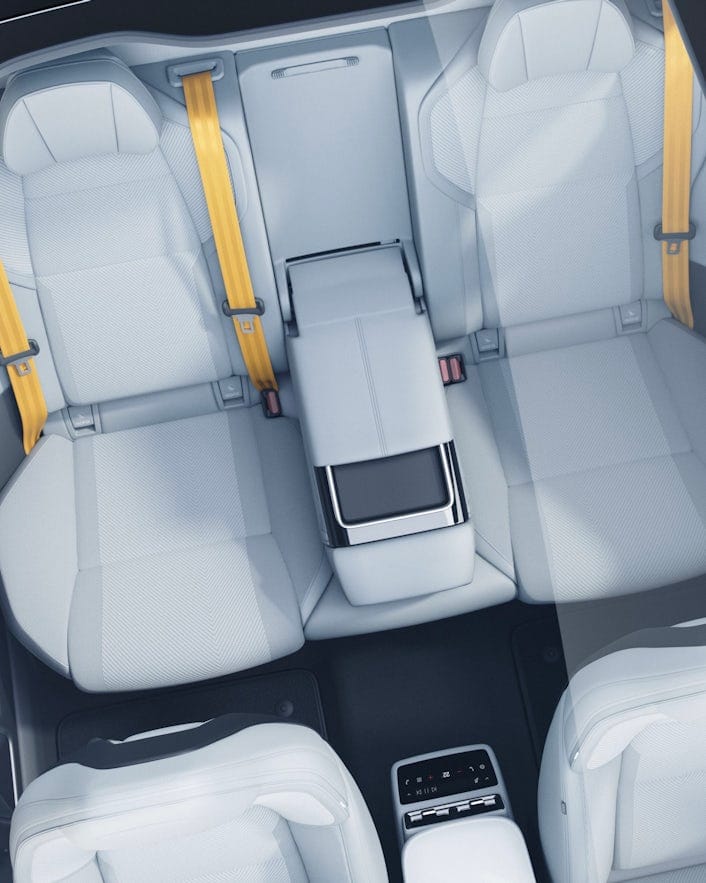 Interior of Polestar car showing four seats, yellow seat belts, center console, and rear climate control panel.