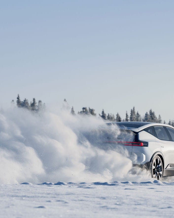 Rear view of Polestar 3 on a winter road with swirling snow